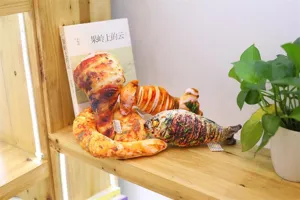 Close-up of funny simulated food plush pillows, featuring chicken leg and fish styles.