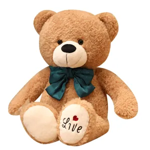 Carino orsacchiotto di peluche marrone con fiocco verde scuro, morbido cuscino regalo.
