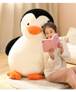 Scena di lifestyle in peluche di pinguino gigante con bambola di stoffa morbida e accogliente.