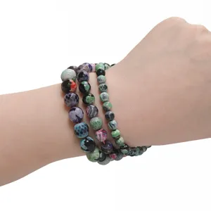 Detailed view of faceted fire agate gemstone bead bracelets worn on hand for handmade DIY.