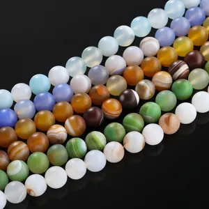 Primer plano de cuentas de ágata rayada mate en varios colores para joyería de bricolaje.