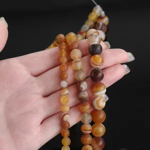Primer plano de detalle de cuentas de ágata mate natural, piedras preciosas marrones para DIY.