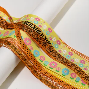 Detailed shot of colorful printed grosgrain ribbon with flower and spiderweb patterns.