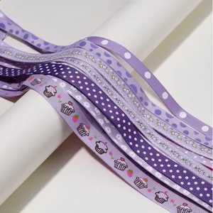 Close-up detail of purple printed grosgrain ribbons with cute cupcake and polka dot patterns.