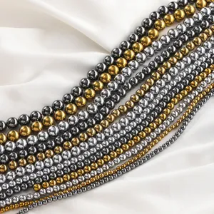 Close-up detail of magnetic hematite round bead strands in gold and silver colors for DIY jewelry.