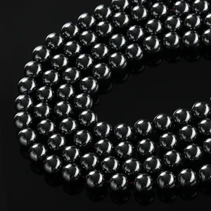 Close-up detail of black hematite magnetic round beads, perfect for DIY jewelry making.
