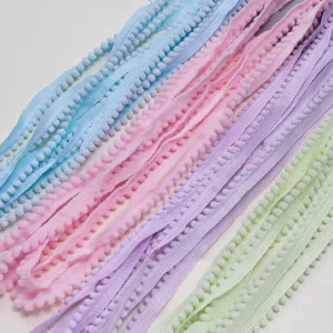 Detail view of colorful polyester pom-pom trim ribbons in pastel shades for DIY crafts.