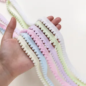 Close-up detail of colorful pom-pom fringe trim, perfect for DIY doll clothes and gift box decor.