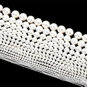Detailansicht weißer Muschelperlen in abgestuften Größen, glatte runde Form für DIY-Schmuck.