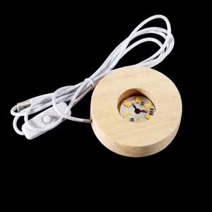 Vue rapprochée de l'intérieur de la base de lampe en bois avec module LED et câble USB blanc.