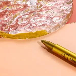 Close-up detail of the metallic gold marker pen drawing on a textured craft surface.
