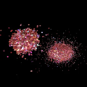 Pink holographic nail glitter sequins close-up, hexagonal flakes and fine flash powder.