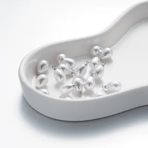 Nahaufnahme von tropfenformigen Perlenanhangern mit Metallosen, ideal fur DIY Schmuck.