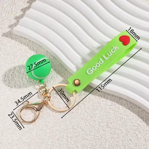 Detailed view of green tennis ball silicone keychain with dimension measurements and Good Luck text.
