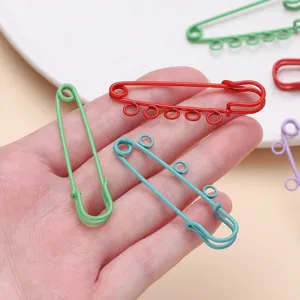 Detail view of colorful painted multi-hole safety pins, ideal for DIY crafts and accessories.