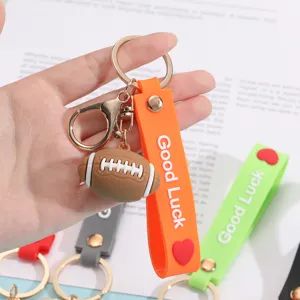 Mini football keychain with orange Good Luck silicone strap, stylish bag charm accessory.