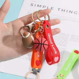 Mini sports ball keychains feature basketball and rugby pendants with colorful silicone straps.