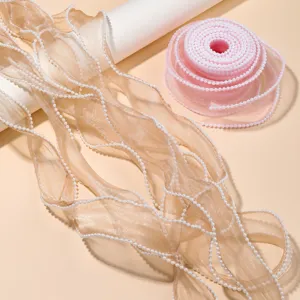 Detailed view of sheer organza ribbon with pearl bead edge for DIY bows and cake decoration.