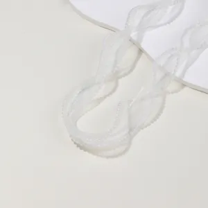 Close-up detail of white sheer ribbon with pearl edge for DIY hair bows and cake decoration.