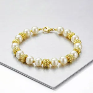 Elegantes Perlenarmband mit abwechselnden weißen Perlen und strukturierten Goldabstandshaltern.