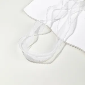 Detail shot of white organza ribbon with delicate pearl edge, perfect for DIY crafts and decoration.