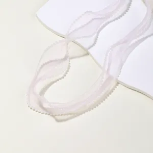 Pearl edge pink organza ribbon detail, sheer mesh fabric closeup for DIY craft decor.