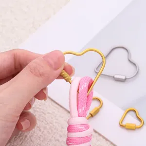 Dettaglio del moschettone a cuore in acciaio inossidabile, connettore dorato per gioielli.