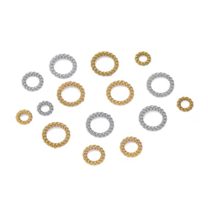 Detailed view of twisted jump rings and spacer beads in gold and silver stainless steel.
