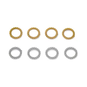 Close-up view of twisted metal jump rings in gold and silver finish, ideal for DIY jewelry crafting.