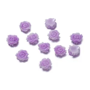 Primo piano di cabochon di rose in resina viola, perfetti per nail art e lavori fai da te.
