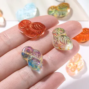 Gros plan détaillé de perles hibou transparentes irisées dorées pour la bijouterie DIY.