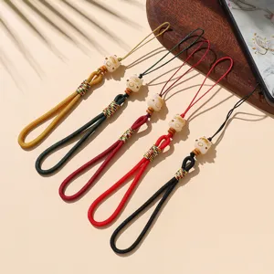 Charmante gelukskat telefoonhanger met kleurrijke gevlochten touwen, fijne details.