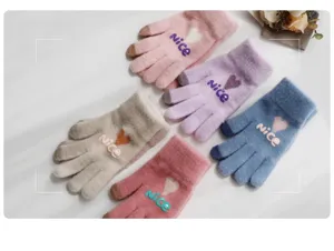 Detail view of colorful winter touch screen warm knit gloves featuring cute heart patterns.