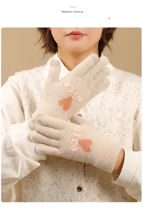 Close-up detail of women winter warm touchscreen knit gloves with cute heart embroidery.