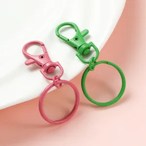 Colorful zinc alloy lobster clasp keychains in pink and green, close-up view of DIY bag charms.