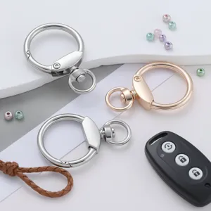 Detalle de anillo llavero de aleación de zinc, mosquetón plateado y oro rosa para bolsos.