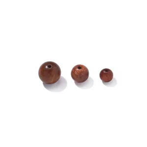 Close-up detail of natural Burmese rosewood loose round beads for DIY bracelets and crafts.
