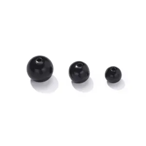 Close-up detail shot of natural black wooden spacer beads, smooth polished surface, drilled.