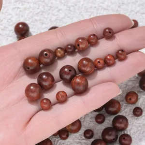 Detail view of natural wood loose beads, smooth round shape, perfect for DIY bracelets.