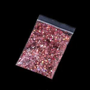 Holographic nail glitter flakes, pink hexagonal sequins in clear bag, nail art decor detail view.
