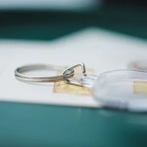Detailed shot of clear acrylic blank photo frame keychain with metal split ring for DIY gifts.