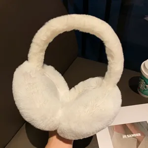Detailed shot of white fluffy winter earmuffs, soft plush texture, cozy cold weather accessory.