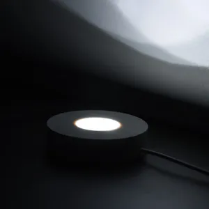 Vue détaillée d'une base lumineuse LED en bois avec éclairage blanc et belle texture.