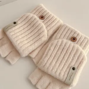 Close-up detail of winter knitted convertible fingerless gloves in soft beige wool with buttons.