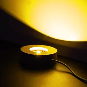 Vue detaillee de la base lumineuse ronde en bois, support eclaire pour boule de cristal.