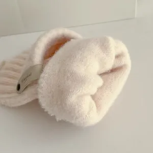 Detailed view of women winter warm knitted flip top gloves, soft fleece lined pink mittens.