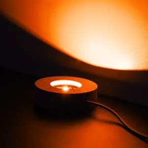 Socle lumineux en bois vue détail, support LED rond pour boule de cristal et veilleuse.