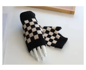 Nahaufnahme von stilvollen schwarz-weißen karierten Strick-Fingerlos-Handschuhen für den Winter.