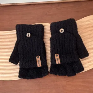 Detail view of women winter warm knitted fingerless gloves in black with cute buttons and tags.