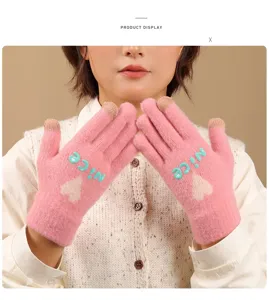 Close-up detail of cute pink knit touch screen gloves with heart and nice embroidery for winter.